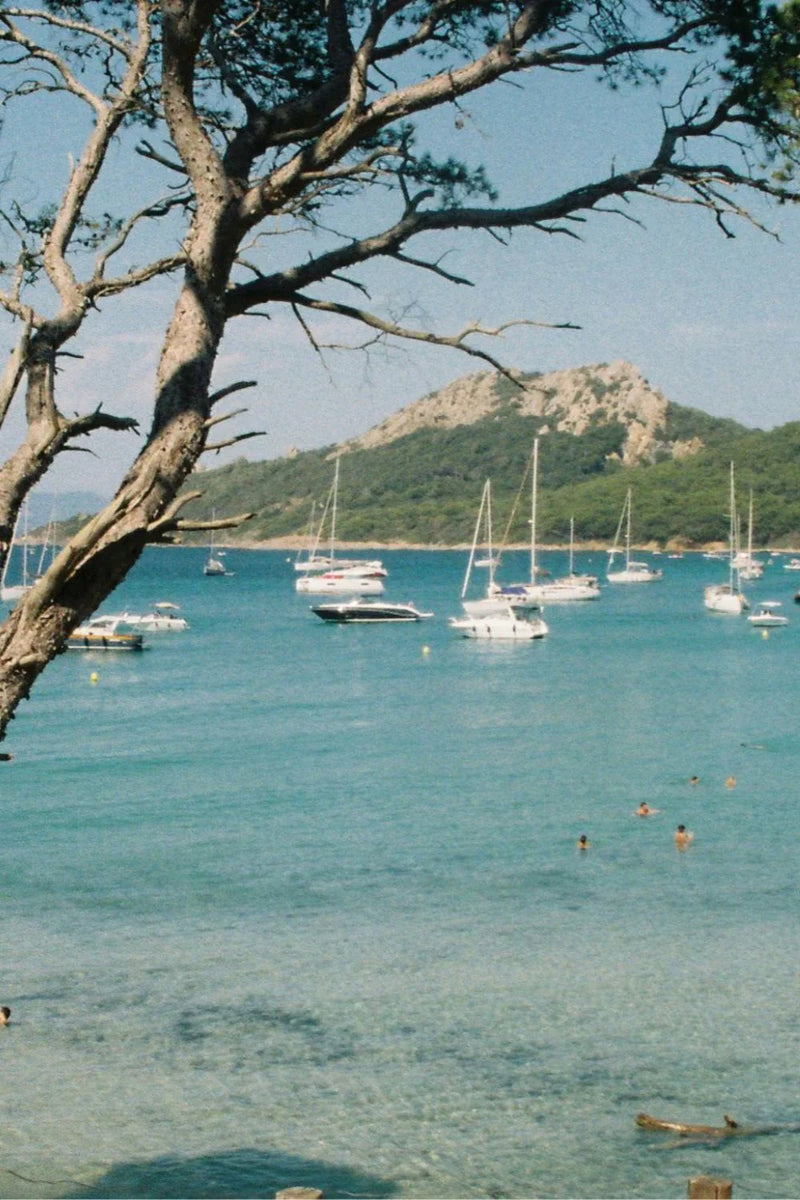 Scenic French Riviera coastline with sailboats, turquoise water, and coastal views in the South of France.